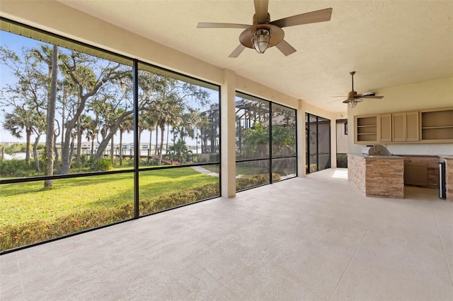 unfurnished sunroom featuring ceiling fan