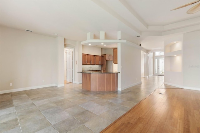 kitchen featuring ceiling fan, sink, light hardwood / wood-style flooring, and tasteful backsplash