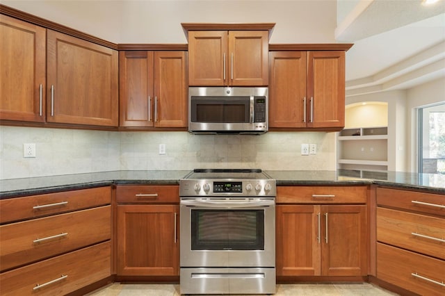 kitchen with dark stone counters, appliances with stainless steel finishes, and tasteful backsplash