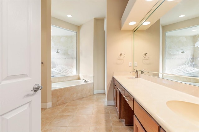 bathroom with tile patterned floors, tiled tub, and vanity