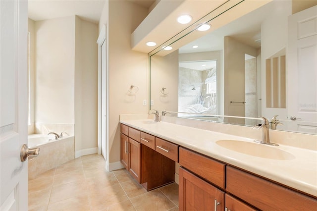 bathroom featuring tiled bath, tile patterned flooring, and vanity