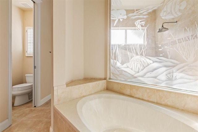 bathroom with tile patterned floors, tiled bath, a healthy amount of sunlight, and toilet