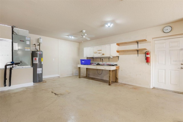 basement with ceiling fan, a textured ceiling, and water heater