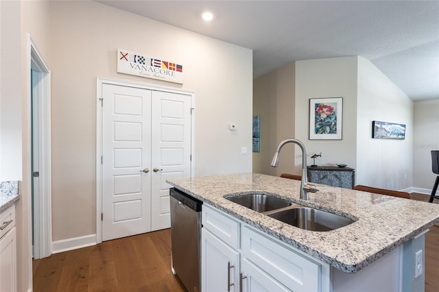 kitchen featuring a center island with sink, sink, stainless steel dishwasher, light stone counters, and white cabinetry