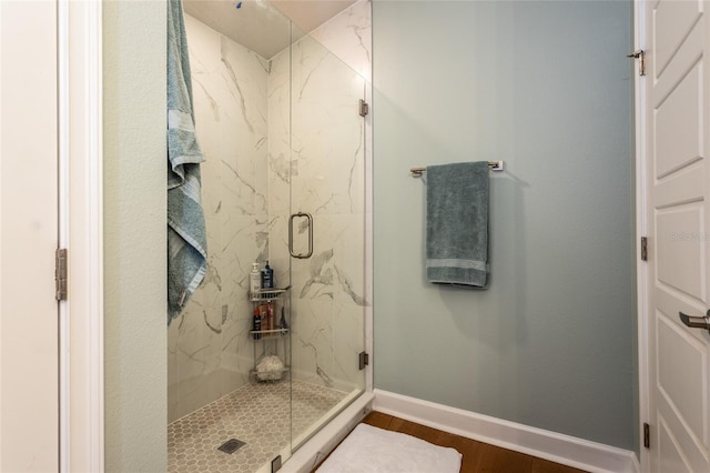 bathroom with hardwood / wood-style floors and a shower with door