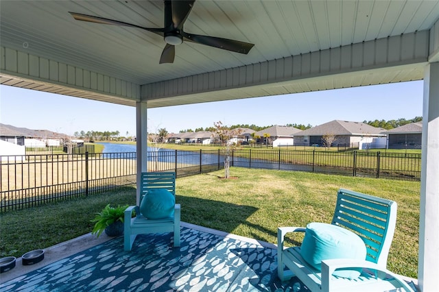 view of yard featuring ceiling fan and a water view