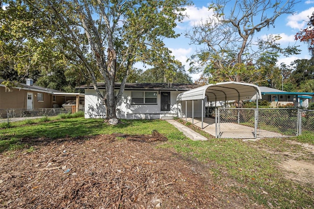 rear view of property featuring a yard and a carport