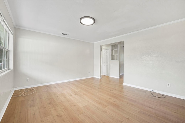 unfurnished room featuring light hardwood / wood-style floors and crown molding