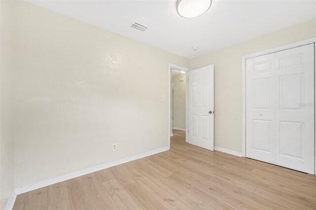 unfurnished bedroom featuring a closet and light hardwood / wood-style flooring