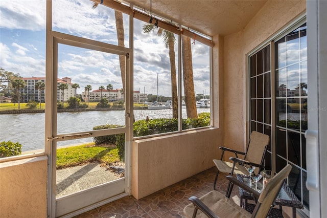 sunroom with a water view and a healthy amount of sunlight