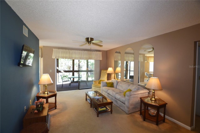 living room with carpet flooring, ceiling fan, and a textured ceiling