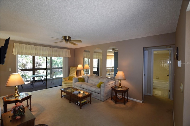 carpeted living room with ceiling fan and a textured ceiling