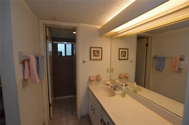 bathroom with vanity, an enclosed shower, and a textured ceiling