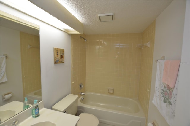 full bathroom with vanity, a textured ceiling, toilet, and tiled shower / bath combo