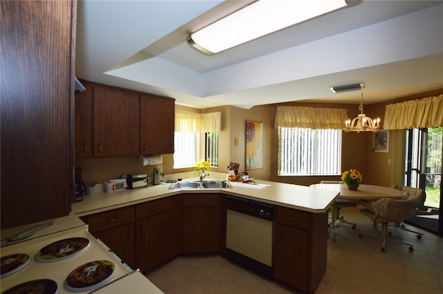 kitchen featuring sink, a notable chandelier, kitchen peninsula, white dishwasher, and a tray ceiling