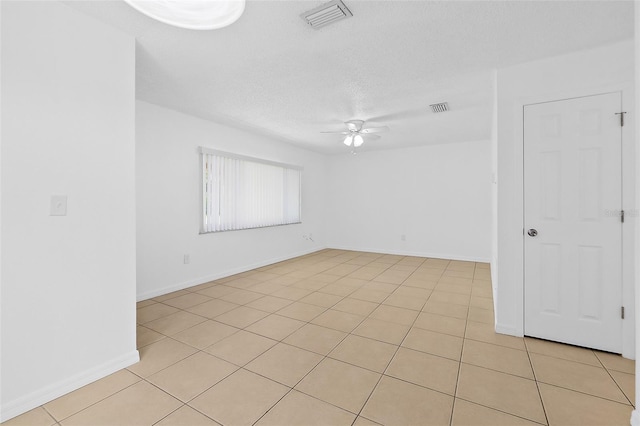 tiled empty room with a textured ceiling and ceiling fan