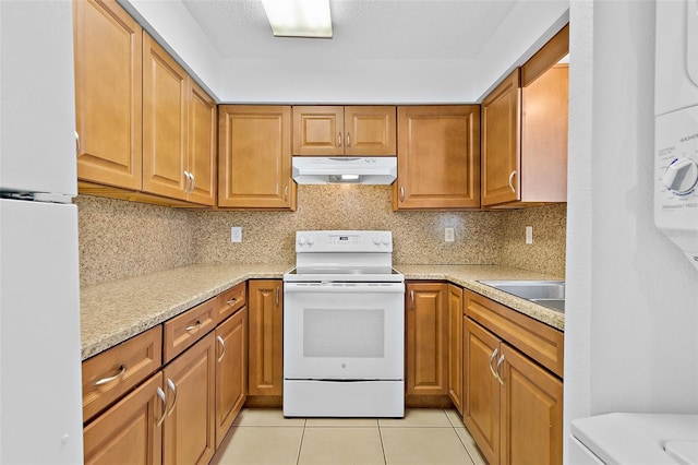 kitchen with tasteful backsplash, light stone counters, white appliances, sink, and light tile patterned floors