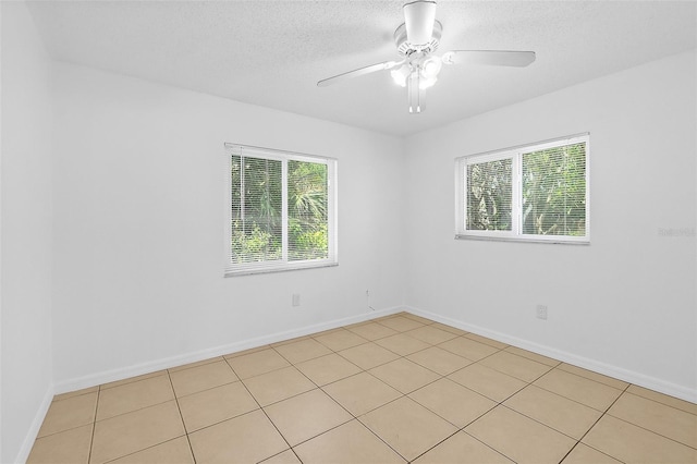 tiled spare room with ceiling fan