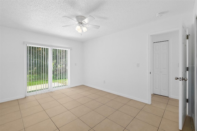 tiled spare room featuring ceiling fan and a textured ceiling