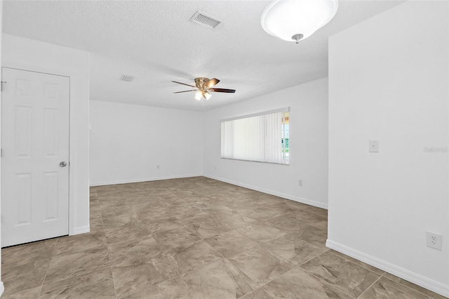 unfurnished room featuring ceiling fan and a textured ceiling