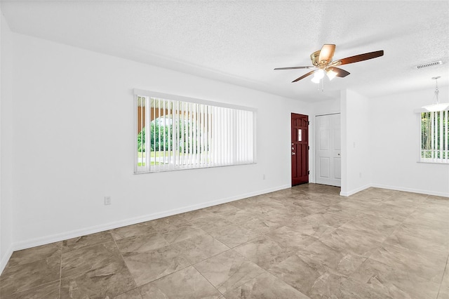 unfurnished room featuring ceiling fan and a textured ceiling