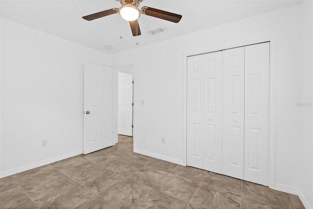 unfurnished bedroom with ceiling fan and a closet