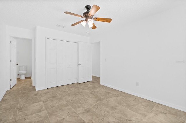 unfurnished bedroom featuring a closet, ceiling fan, and ensuite bathroom