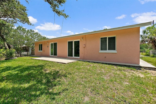 rear view of property with a lawn and a patio area