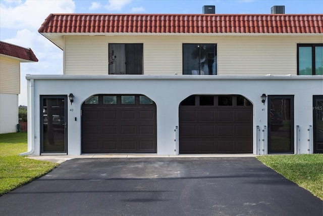 view of front of property featuring stucco siding, aphalt driveway, and a tiled roof