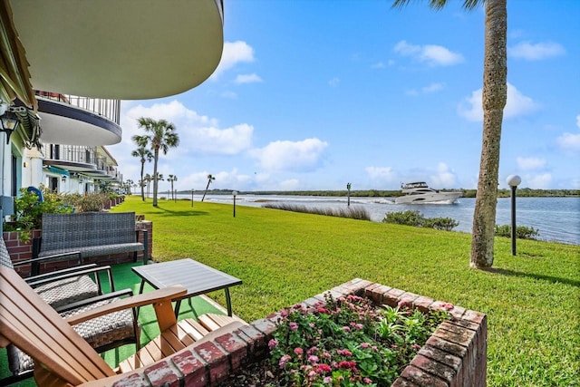 surrounding community with a yard and a water view