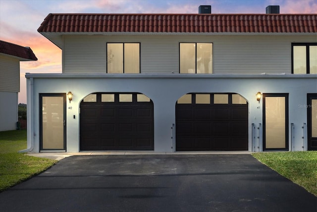 view of front of home featuring a tile roof, driveway, and stucco siding