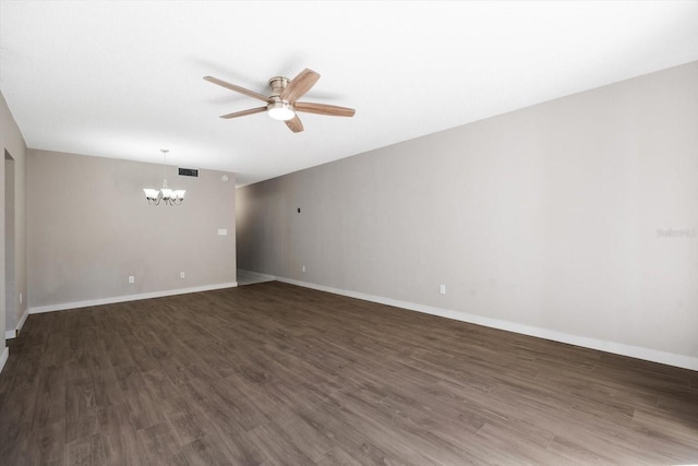 empty room featuring ceiling fan with notable chandelier and dark hardwood / wood-style flooring