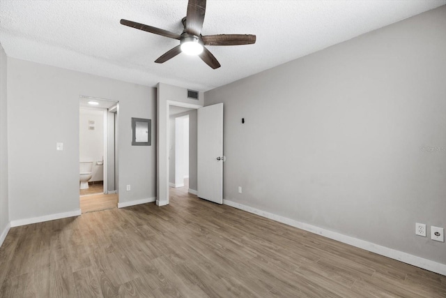 unfurnished bedroom featuring a textured ceiling, ceiling fan, light wood-type flooring, and ensuite bathroom