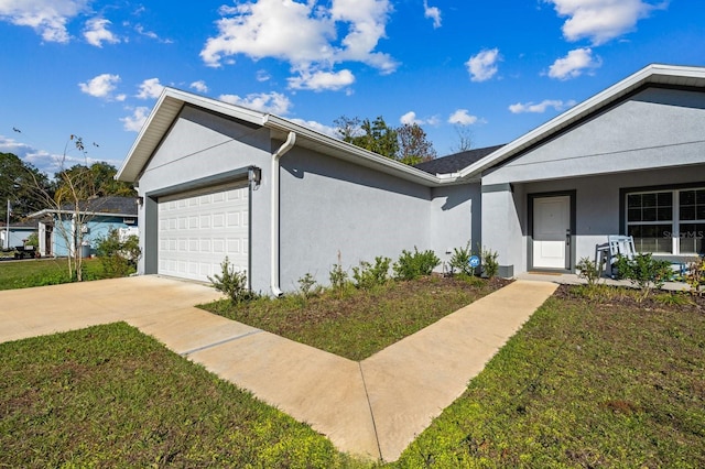 ranch-style home featuring covered porch, a garage, and a front yard