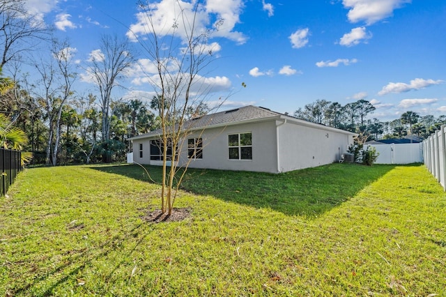 rear view of property featuring a lawn and cooling unit