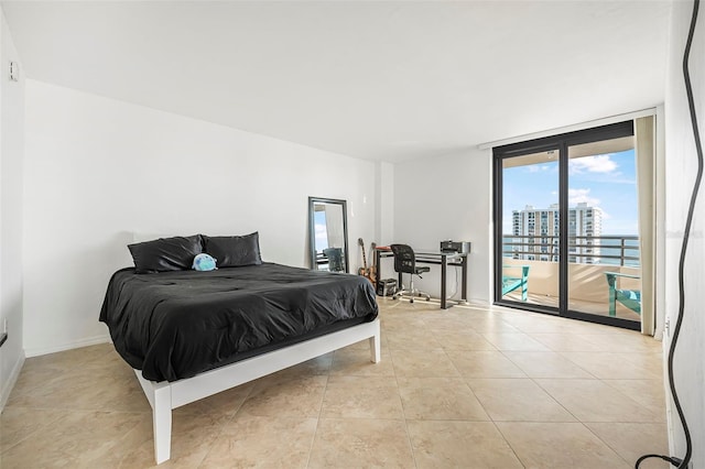 tiled bedroom featuring access to exterior and a wall of windows