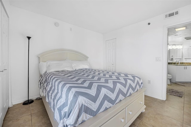 tiled bedroom featuring sink and connected bathroom