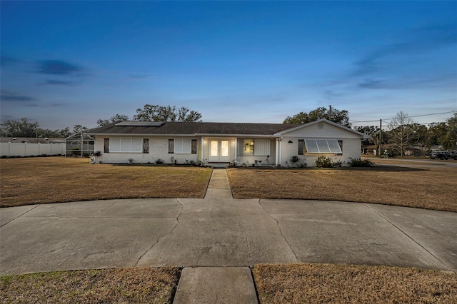 ranch-style house featuring a yard and solar panels