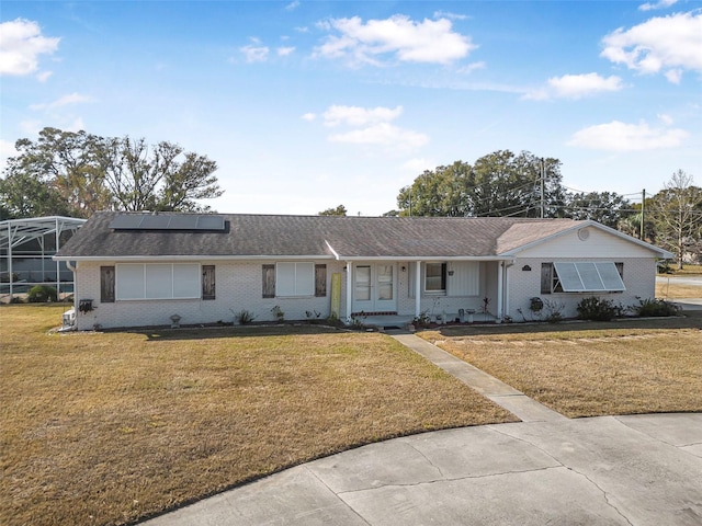 ranch-style house with a front lawn and solar panels