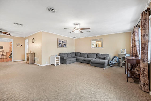 living room with ceiling fan, ornamental molding, and light carpet