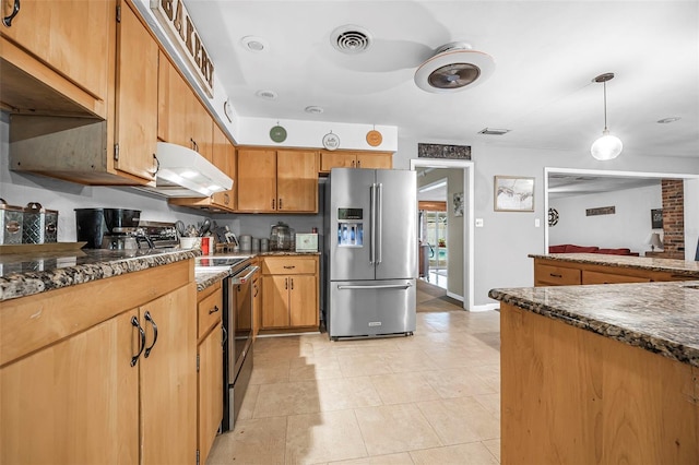 kitchen featuring stainless steel appliances, dark stone counters, and pendant lighting