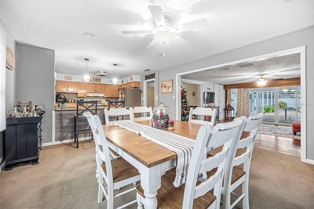 carpeted dining room featuring ceiling fan