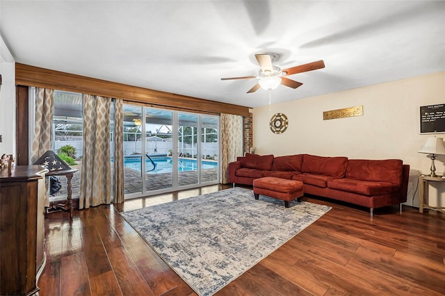 living room with ceiling fan and dark hardwood / wood-style flooring