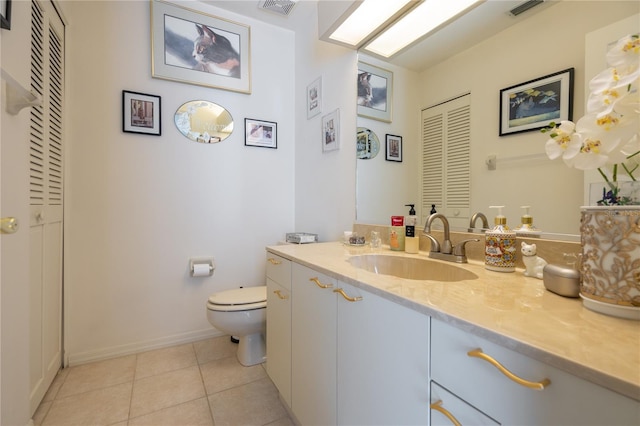 bathroom with tile patterned flooring, vanity, and toilet