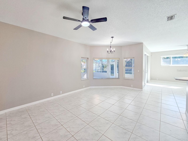 tiled spare room with ceiling fan with notable chandelier and a textured ceiling