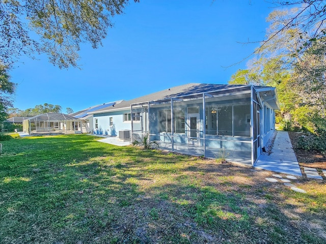 rear view of property featuring central AC unit, a lawn, and glass enclosure