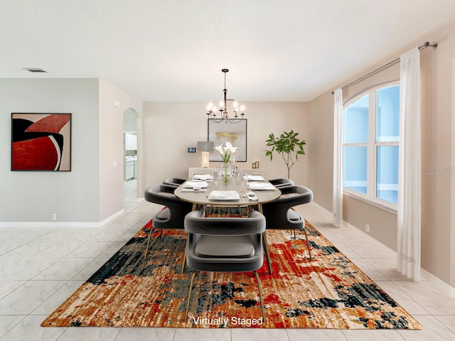 tiled dining area featuring a chandelier