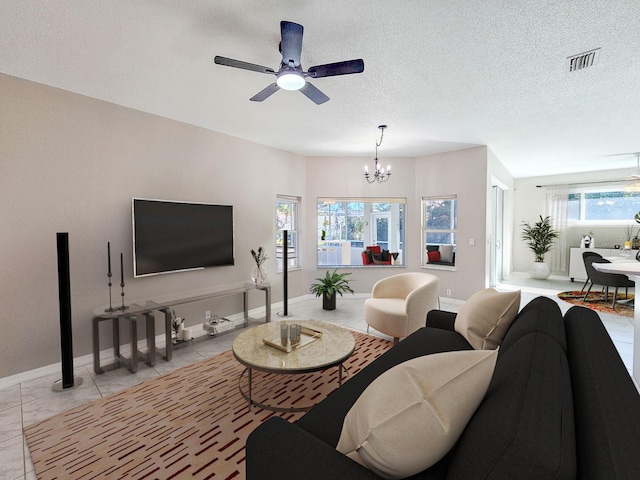 tiled living room with a textured ceiling, a wealth of natural light, and ceiling fan with notable chandelier