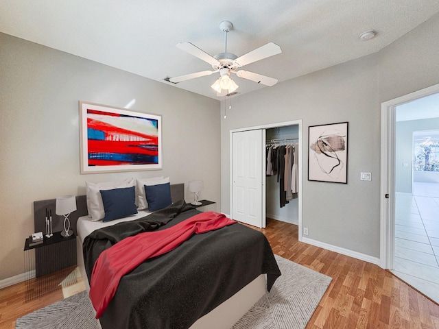 bedroom with ceiling fan, light hardwood / wood-style flooring, and a closet