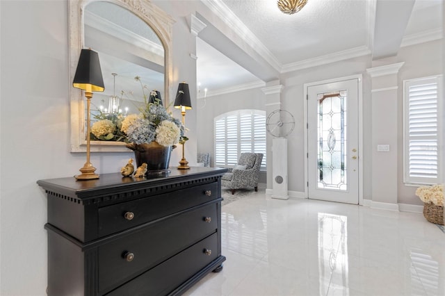 foyer entrance featuring decorative columns, crown molding, and a textured ceiling